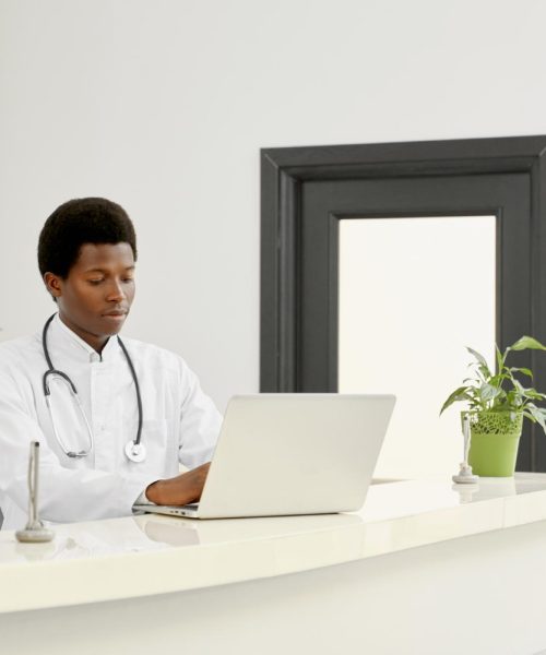 african-doctor-coat-using-laptop-reception
